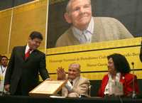 Héctor García recibió de manos del rector de la Universidad de Guadalajara, Carlos Briseño, el reconocimiento concedido por el Premio de Periodismo Cultural Fernando Benítez, en la FIL