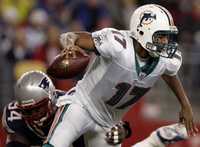 Cleo Lemon, quarterback de Miami, es detenido por Ty Warren, de Patriotas