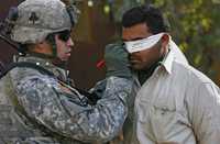 Un soldado estadunidense clasifica a un detenido iraquí cerca de Baiji antes de ser interrogado