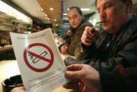 En Lille, al norte de Francia, un cliente de un bar observa uno de los letreros que anuncia la próxima prohibición de fumar en sitios públicos