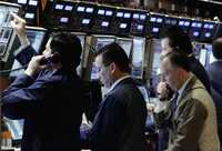 Empleados de Cutton & Co en el mercado de cambios de Nueva York. Wall Street tuvo ayer pérdidas debido a los malos resultados de la industria manufacturera y al alza en los precios del petróleo