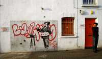 Un joven pasa al lado del mural de Banksy que fue subastado por eBay