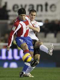 Helguera (derecha) del Valencia, disputa el balón al Kun Agüero