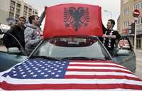Kosovares adornan con una bandera albanesa y otra estadunidense su automóvil para celebrar la independencia de la provincia serbia