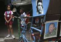 Tras el anuncio de Fidel Castro de separarse definitivamente de sus cargos al frente del gobierno cubano, la vida en La Habana se desarrolló casi como cualquier día normal. En la imagen, unos niños conversan al lado de un bicitaxi adornado con imágenes del Che Guevara y el comandante