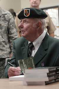 Robin Moore firma libros para las fuerzas armadas apostadas en el fuerte Campbell, en 2005