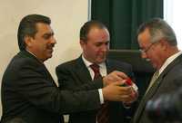 Los legisladores Andrés Galván y Luis Alberto Villarreal le muestran una cajetilla de cigarros a Ernesto Saro, presidente de la Comisión de Salud, ayer durante la sesión del Senado en que se aprobó la ley antitabaco