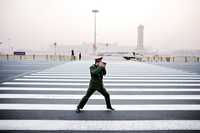 Un policía paramilitar fotografía a un compañero en la plaza de la Puerta de la Paz Celestial, este lunes, en Pekín