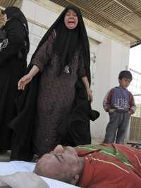 Una mujer observa el cuerpo de su esposo, quien yace en la morgue de Baqouba, capital de la provincia iraquí de Diyala, tras ser víctima de fuego cruzado entre hombres armados y policías cuando se dirigía a su trabajo