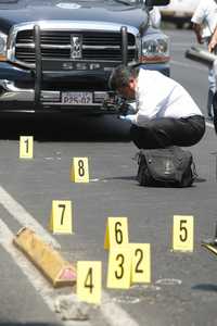 Un policía toma evidencia en el lugar en que fue asesinado Conrado Hernández