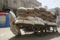 Trabajadores empujan un carro cargado con sacos de arroz en un mercado de Karachi. Pakistán es el cuarto exportador mundial de arroz. Produjo aproximadamente 5.5 millones de toneladas en la cosecha 2007/08 y después de restar el consumo interno debería tener un excedente exportable de aproximadamente 3.3 millones de toneladas