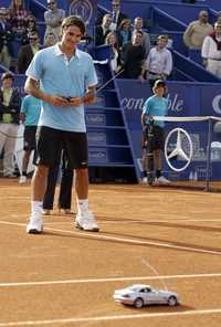 El tenista suizo Roger Federer se divierte con un carrito a control remoto, luego de vencer al belga Olivier Rochus en el Abierto de Estoril