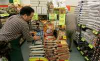 El encargado de un supermercado en San Francisco, California, acomoda bolsas de arroz basmati en los mostradores, que ya reflejan un aumento en los precios al consumidor