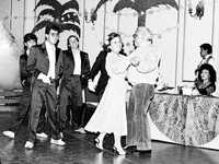 Carlos Monsiváis y Elena Poniatowska bailan un vals durante la fiesta sorpresa que se le hizo al escritor al cumplir 50 años, en el salón Margo, en 1988. Observa la escena la actriz y cantante María Victoria
