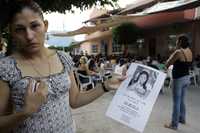 Una hija de Rogaciano Alva muestra un cartel con la foto de su hermana Ana Karen, quien fue secuestrada