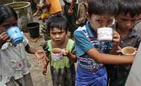 Niños hacen fila para recibir agua no contaminada, ayer en las afueras de Yangón. La junta militar de Myanmar ha alertado de posibles contagios
