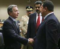 Los presidentes Álvaro Uribe y Hugo Chávez se saludan durante la apertura de la reunión para formar la Unión de Naciones Sudamericanas