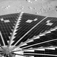 Una de las imágenes captadas, en la que se observa en primer plano celdas de un panel solar y en segundo plano parte de la superficie marciana