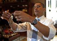 Barack Obama, precandidato presidencial demócrata y senador por Illinois, examina algunas joyas que pretendía comprar para su familia, ayer en una tienda de Rapid City, Dakota del Sur