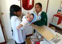 Una mujer indígena lleva a su hija a la consulta en una de las unidades hospitalarias del IMSS
