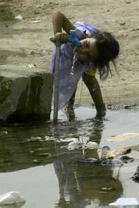 Una pequeña bebe agua en un campo de refugiados a 20 kilómetros de la ciudad de Najaf en el sur de Irak. Imagen de archivo