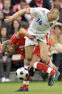 El mediocampista checo David Jarolim es detenido por el suizo Valon Behrami, en el partido inaugural de la Eurocopa 2008 que los helvéticos organizan junto con Austria