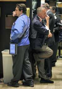 Corredores de la bolsa de Nueva York, durante la jornada de ayer, cuando los títulos de las principales empresas cayeron con fuerza