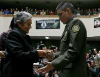 Durante una ceremonia religiosa ayer en Bogotá, el sargento John Jairo Durán entrega a Emperatriz de Guevara el diario de su hijo, el mayor Julián Guevara, secuestrado por las FARC y muerto en cautiverio hace dos años. Al acto asistieron cuatro de los policías liberados con Ingrid Betancourt