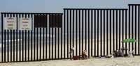 "Las mojoneras no se explican plenamente por sí mismas, pero ofrecen un punto de referencia que se puede compartir." En la gráfica, una familia descansa en una playa de la zona de Tijuana, en Baja California, junto al muro que divide México y Estados Unidos