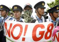 Policías montan guardia mientras manifestantes opositores al G-8 se expresan en la ciudad de Sobetsu, cerca de la sede de la cumbre de dicho grupo, en la isla japonesa de Hokkaido, el 9 de julio