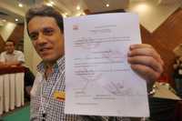 Alberto Begné muestra a los medios de comunicación el documento que lo acredita como presidente del Partido Socialdemócrata