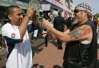 Un minuteman (a la derecha) y un activista de Naui Huitzilopochtli, se confrontan con sus cámaras durante una protesta afuera del Centro de Convenciones de San Diego donde ayer el precandidato demócrata a la presidencia de Estados Unidos, Barack Obama, pronunció un discurso ante la comunidad latina