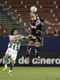 Christian Giménez (derecha) disputa el balón con Jorge Iván Estrada en el empate que permitió a los Tuzos seguir en la pelea por la Superliga