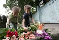 Dos niños depositan flores en la puerta de la casa de Alexander Solzhenitsyn, ubicada en las afueras de Moscú