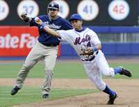 Argenis Reyes, de los Mets, tira a primera para poner out al bateador de los Padres, Kevin Kouzmanoff, tras haber forzado al corredor Adrián González, en la sexta entrada del partido entre sus escuadras