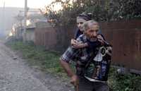 Una pareja de ancianos georgianos escapa de sus casas incendiadas por milicianos sudosetios en Kvemo-Achebeti