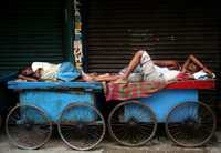 Dos hombres duermen en la ciudad de Kolkata, India. La huelga nacional de un día fue un gran éxito, declararon los sindicatos