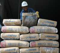 Un trabajador descarga bultos de cemento, para su distribución y venta, de la expropiada planta de Cemex en Venezuela