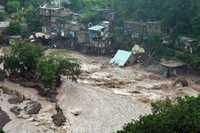 Una casa es arrastrada en Kingston por las aguas que precipitó Gustav en Jamaica. El paso del meteoro dejó en el país al menos 11 muertos