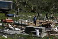 Residentes de La Palma, Cuba, buscan algunas pertenencias entre los escombros de sus casas tras el paso de Gustav