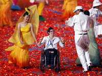 Una atleta paralímpica se incorpora al grupo de bailarines que actuó en la clausura de la justa china
