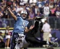 El mariscal de campo de Titanes, Kerry Collins, lanza un envío a pesar del intento de Jarret Johnson de evitarlo, durante el partido ante Baltimore