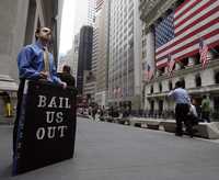 Un hombre protesta frente a la bolsa de Nueva York, mientras gobiernos de todo el mundo se afanan por asegurar liquidez a los sistemas bancarios