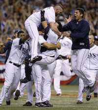 David Price celebra con el cátcher Dioner Navarro y otros beisbolistas el triunfo que permite a Mantarrayas jugar la Serie Mundial por primera vez