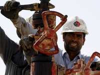 Empleados de la Compañía Petrolera de Bahrein, en la zona del Golfo Pérsico, trabajan en la válvula de un gasoducto
