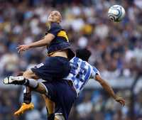Luciano Figueroa, de Boca Juniors, pelea por el esférico con Gabriel Mercado, de Racing Club, en partido disputado en La Bombonera