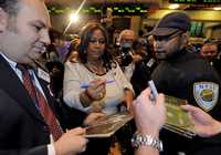La cantante Aretha Franklin firma autógrafos para operadores de mercado en el piso de remates de la bolsa de Nueva York