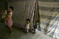 Una mujer con sus tres hijos en una casa en Petare, una de las poblaciones más pobres de Caracas