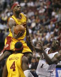 LeBron James, de Cavaliers de Cleveland, dispara en las alturas una canasta, sorteando la presión de los Sixers de Filadefia