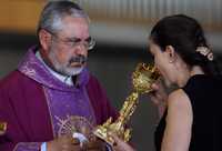 Ingrid Betancourt bebe el vino de consagrar durante la liturgia que encabezó el rector de la Basílica de Guadalupe, Diego Monroy